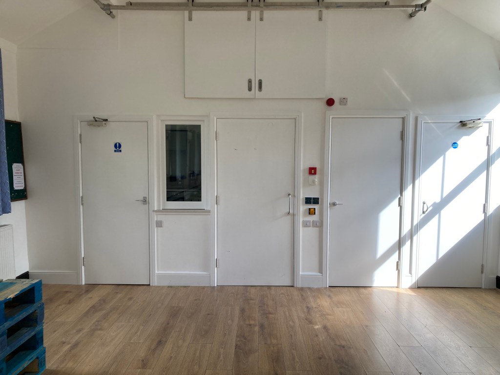 View of the hall showing the new kitchen end. doors for the kitchen, disabled toilet, store and stairs